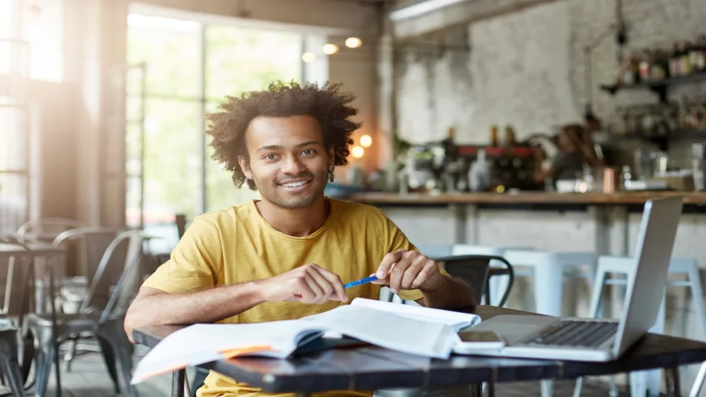 5 dicas para fazer uma boa prova de concurso homem-positivo-sentado-na-mesa-de-um-cafe-usando-um-laptop